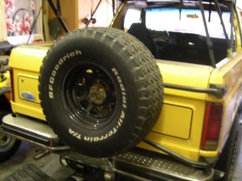 1982 Ford Bronco - Rear view of a yellow Ford Bronco, likely from the early 1980s, with a spare tire mounted on the tailgate.
