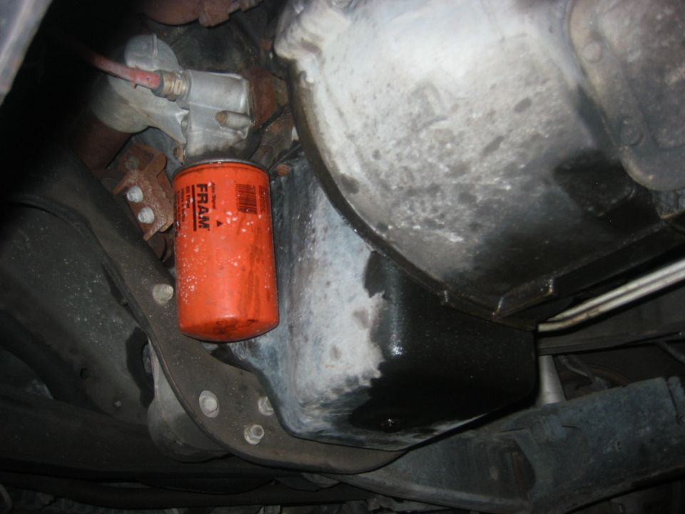 Orange FRAM oil filter and greasy oil pan