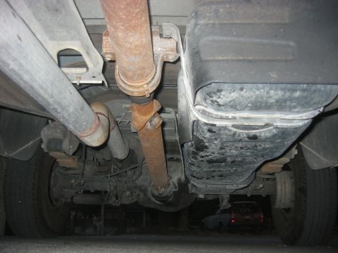 1989 Ford Bronco - Underside view of a vehicle's drivetrain components, including exhaust and driveshaft.