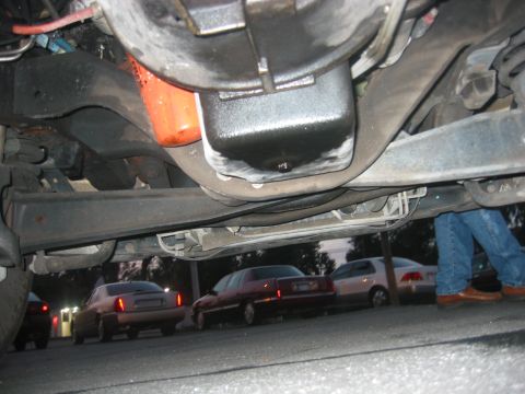 1989 Ford Bronco - Underside view of a vehicle's oil pan and filter, with other cars visible in the background.