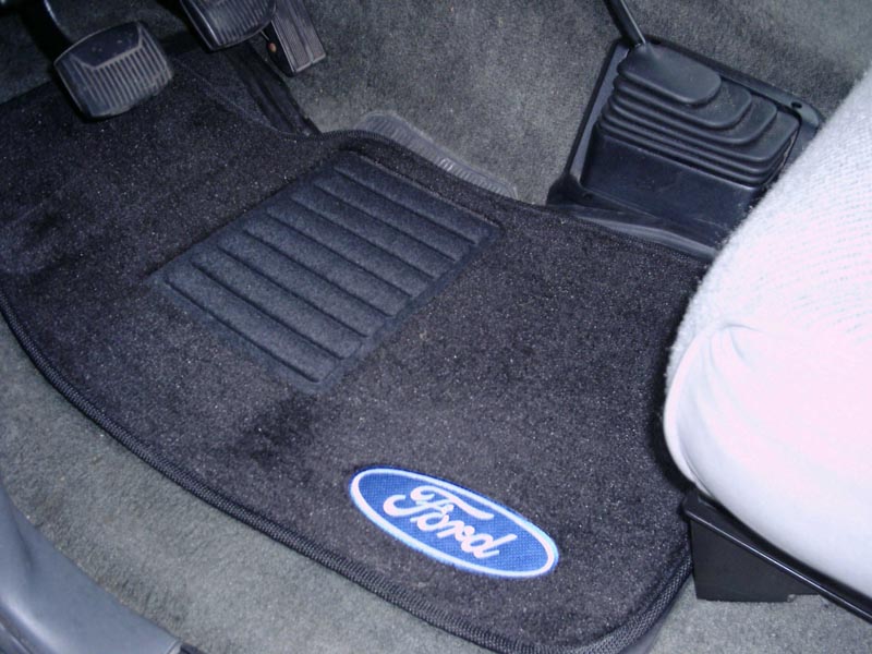 Black Ford-logo floor mat in a manual truck driver footwell