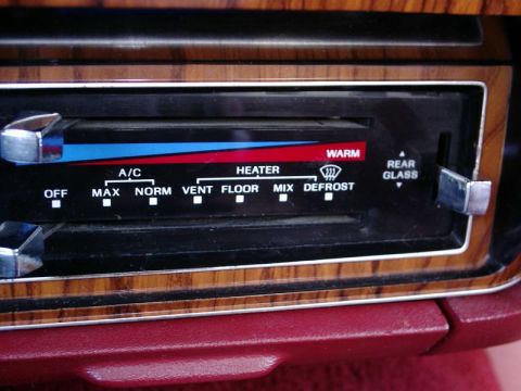 1984 Ford Bronco - Close-up of the climate control panel, wood grain accents and various function labels like A/C, Heater, and Defrost.