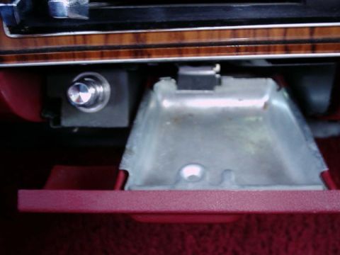 1984 Ford Bronco - Interior view of a 1984 Ford Bronco, focusing on the ashtray and a dash-mounted button.