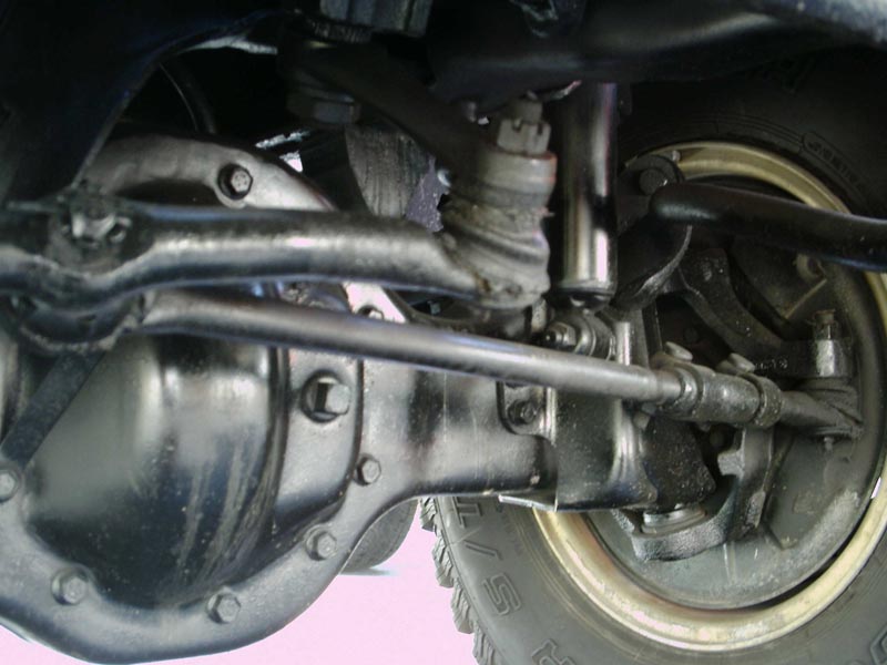 Close-up of front axle, tie rod, and ball joint assembly