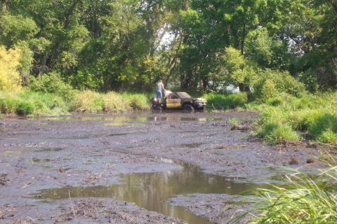 1985 Toyota T100 - Truck stuck in mud with a person attempting to free it.