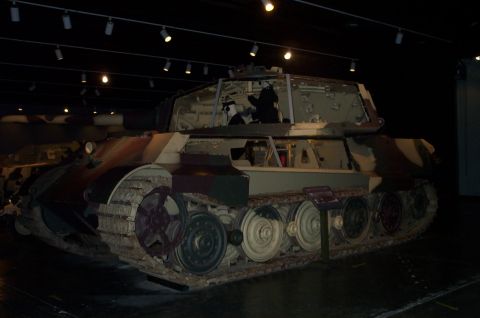 1998 Ford Crown Victoria - A tank with a camouflage paint scheme is on display in a museum setting.