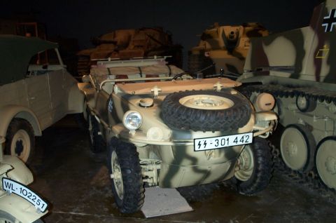 1998 Ford Crown Victoria - A camouflaged German Kübelwagen is displayed indoors with other military vehicles.