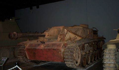 1998 Ford Crown Victoria - A heavily weathered tank sits on display, with another vehicle visible behind it.