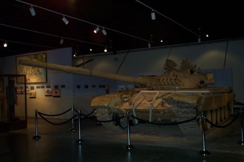 1998 Ford Crown Victoria - A tan tank is displayed in a museum setting, with its long barrel and tracks visible.