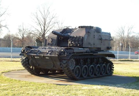 1998 Ford Crown Victoria - A military tank, marked with '1951', is displayed outdoors on a concrete pad.