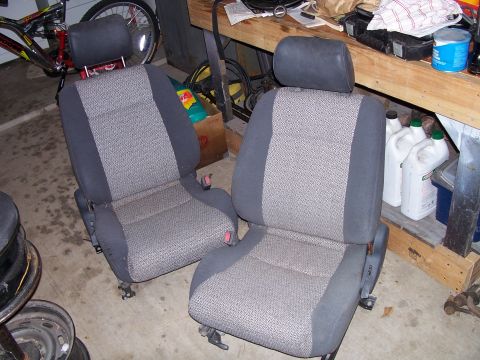 1982 Ford Bronco - Pair of car seats, likely from an older model vehicle, are stored indoors.