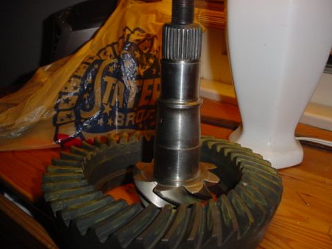 1988 Ford Bronco - Close-up of automotive differential gears and a pinion shaft, with a branded bag in the background.