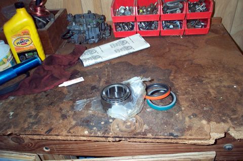 1978 Dodge Power Ram - Workbench setup with various automotive parts and tools, including oil and hardware.