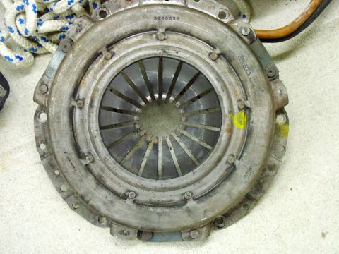 2003 Ford Mustang - A close-up view of a vehicle's clutch pressure plate, showing some wear and part markings.