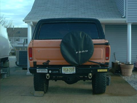 1978 Ford Bronco - Rear view of a 1978 Ford Bronco, showing the spare tire, license plate, and aftermarket bumper.