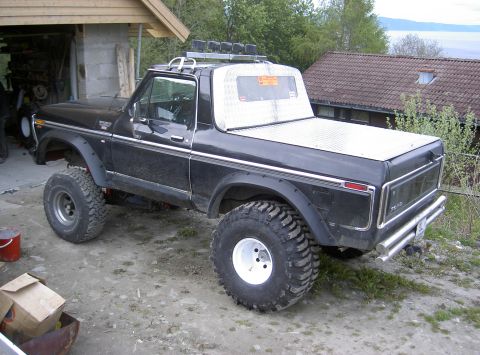1979 Ford Bronco - This lifted 1979 Ford Bronco features aggressive off-road tires and a custom bed cover, ready for adventure.