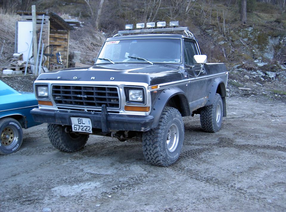1979 Ford Bronco parked on dirt, front quarter view. Another vehicle is partially visible to the left
