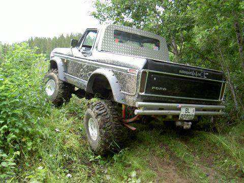 1979 Ford Bronco - Off-road modified 1978 Ford Bronco navigating a grassy, wooded trail.