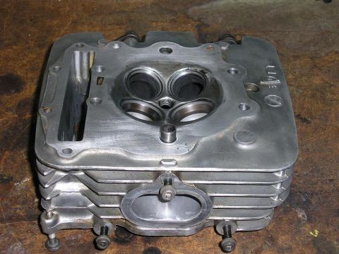 1900 Honda Big Red - Close-up of an engine cylinder head, showing internal components and part of the SuperMotors.net logo.