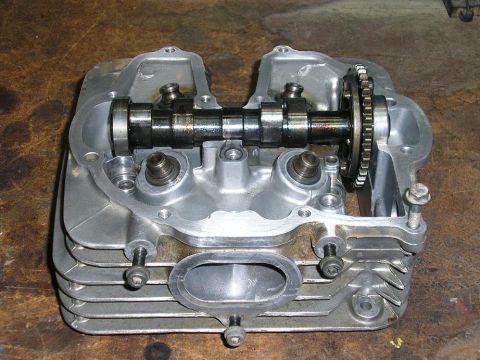 1900 Honda Big Red - Close-up of a disassembled motorcycle engine cylinder head, showing internal components.