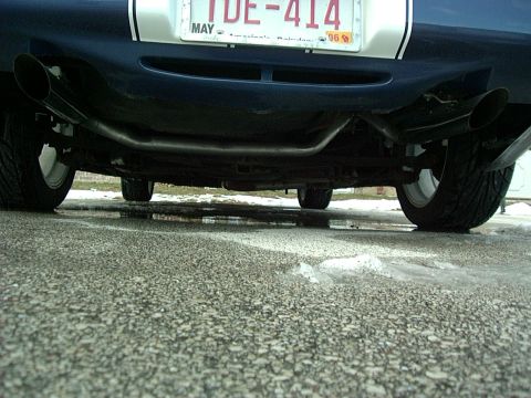 1995 Ford Probe - The rear underside of a 1995 Ford Probe is visible, dual exhaust pipes and a license plate.