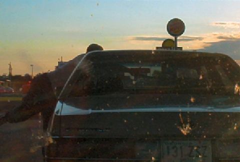 1985 Ford LTD Crown Victoria - A dark sedan is seen from the rear, with a license plate visible.