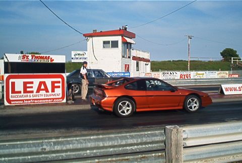 1985 Ford LTD Crown Victoria - Two cars line up at the St. Thomas Dragway, with LEAF Racewear signage visible.
