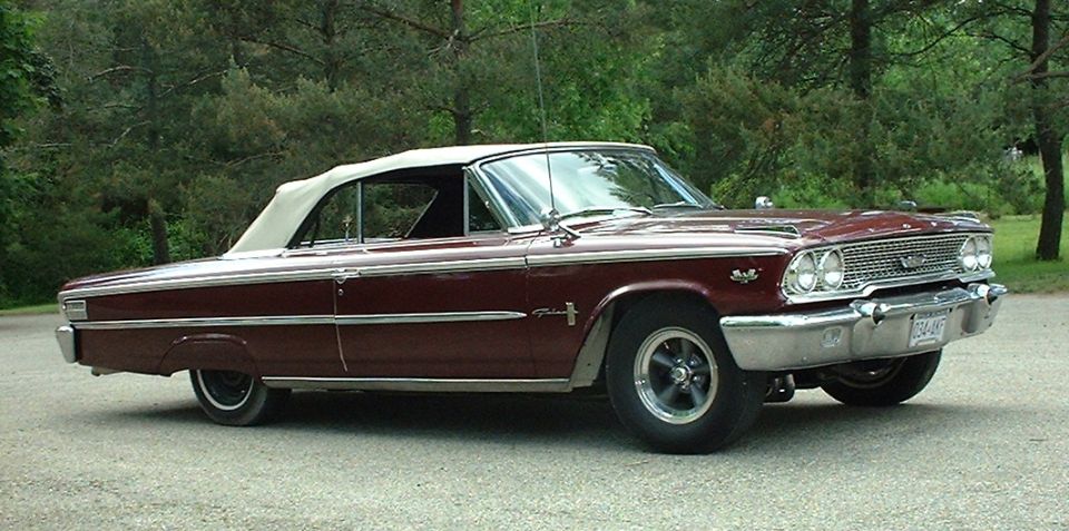 Maroon Ford Galaxie convertible, top up, driver-side profile on gravel