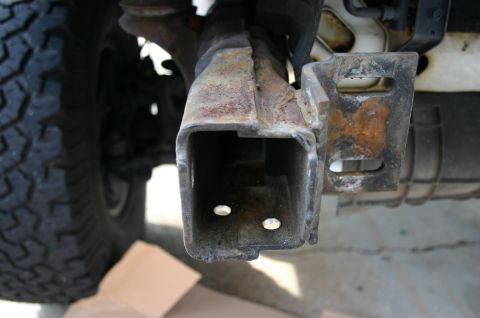 1994 Ford Bronco - The tow hitch receiver shows significant rust and wear, indicating it is a functional part rather than a decorative element.