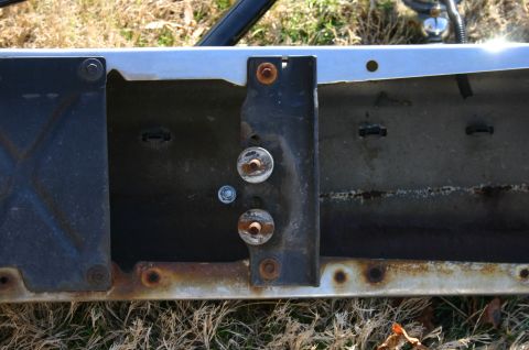 1994 Ford Bronco - Close-up view of the rusty recovery points on a vehicle's frame, showing mounting hardware.