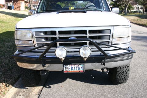 1994 Ford Bronco - 1992 Ford Bronco front end with aftermarket brush guard and lights. The grille and headlight design are characteristic of this model year.