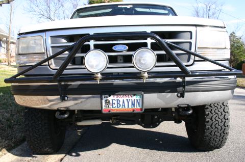 1994 Ford Bronco - This truck features a heavy-duty brush guard and recovery hooks, indicating it's built for off-road use.