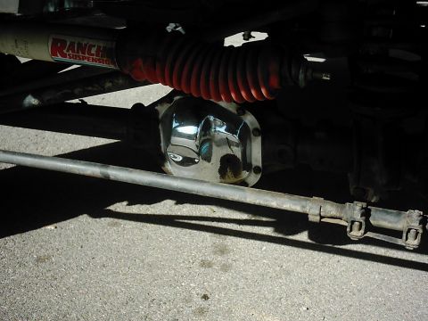 1978 Ford Bronco - Close-up view of a chrome differential cover and a Ranchero suspension shock absorber.