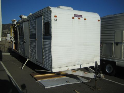 1968 Ford Mustang - A damaged trailer sits parked next to another trailer under a clear blue sky.