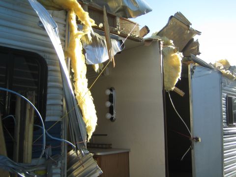 1968 Ford Mustang - Trailer shows significant damage to its exterior and roof structure.