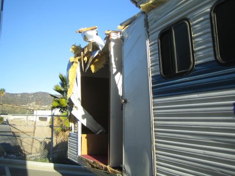 1968 Ford Mustang - A trailer has sustained significant damage to its roof and side, revealing its internal structure.