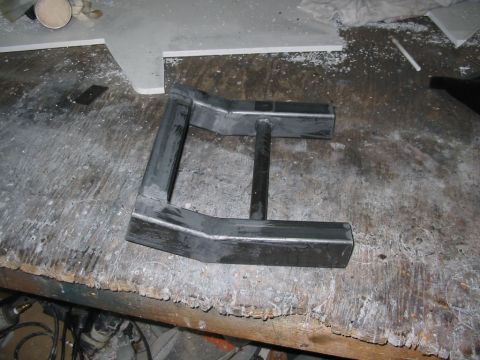 1985 Ford Crown Victoria LTD - A custom-made metal component rests on a worn wooden surface, possibly awaiting installation.