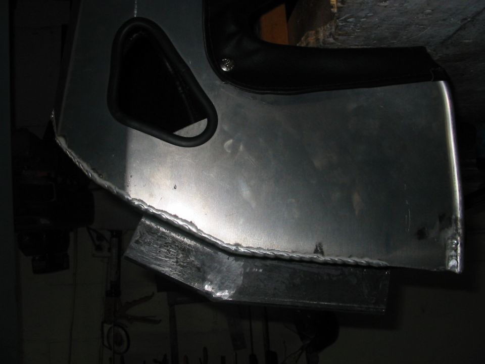 Close-up of custom aluminum fabrication with visible welds and a black trim piece