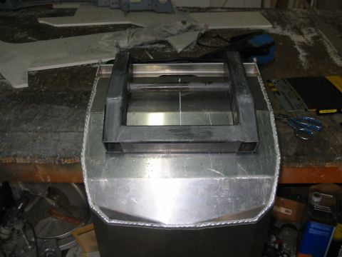 1985 Ford Crown Victoria LTD - A custom metal part is shown on a workbench, with tools and materials scattered around.