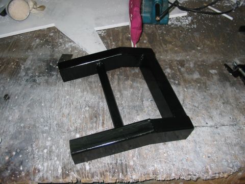 1985 Ford Crown Victoria LTD - A black metal component rests on a cluttered workbench, with a Supermotors.net logo visible in the lower right corner.