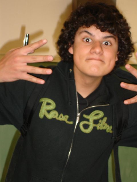 1993 Ford Taurus - A young person with curly hair makes a funny face while wearing a black hoodie with 'Rosa Libre' embroidered in green.