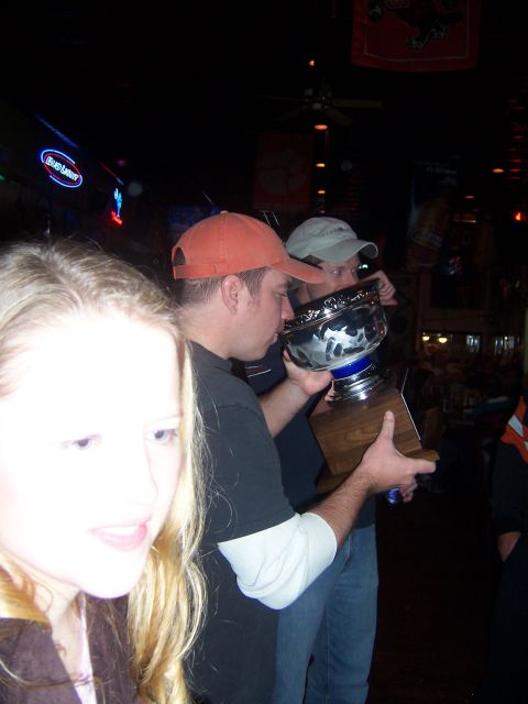 1985 Ford LTD Crown Victoria - A group of people celebrate with a large trophy in a bar, possibly after a hockey game.
