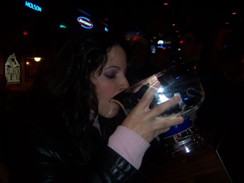 1985 Ford LTD Crown Victoria - Woman drinks from a large trophy in a bar with Molson and other neon signs visible.