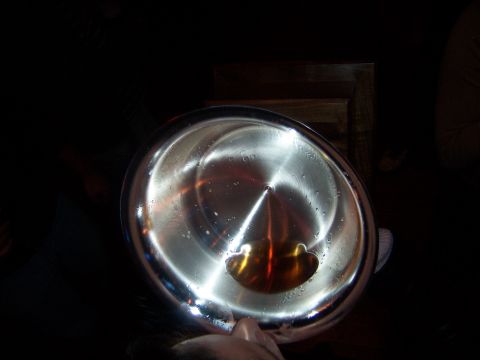 1985 Ford LTD Crown Victoria - A close-up view of a metal bowl containing a small amount of amber liquid and water droplets.