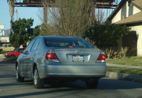 1993 Ford Taurus - Silver sedan seen from the rear, with its third brake light illuminated.