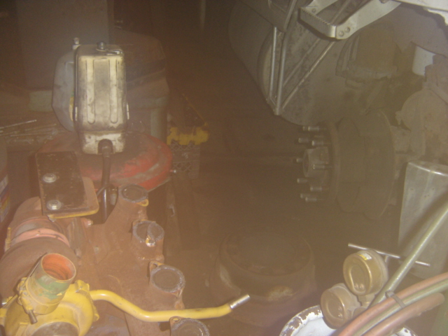 Close-up of rusty engine components and a large tire with lug nuts