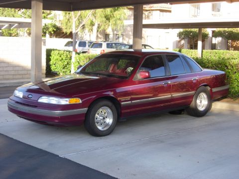 1992 Ford Crown Victoria - This 1992 Ford Crown Victoria features Weld Draglite wheels and a deep maroon paint job, seen here parked under a covered area.
