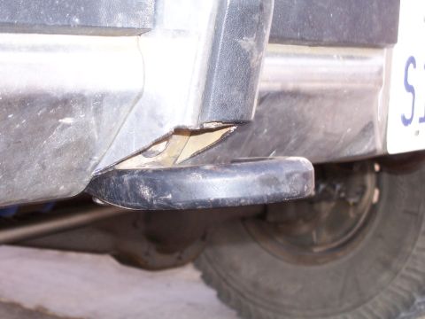 1982 Ford Bronco - The rear bumper step pad is damaged, revealing the underlying metal structure of the vehicle.