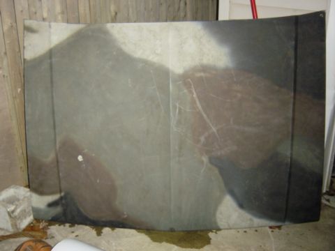 1987 Suzuki Samurai - A camouflaged car hood lies flat, showing signs of wear and tear.