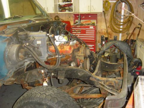 1987 Suzuki Samurai - The engine bay of a vehicle is shown with its engine and chassis exposed, indicating it is undergoing repairs.